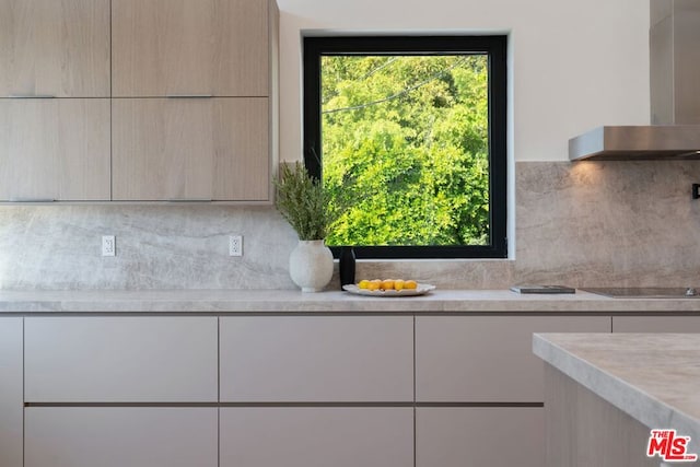 interior space with black electric cooktop, tasteful backsplash, and wall chimney exhaust hood