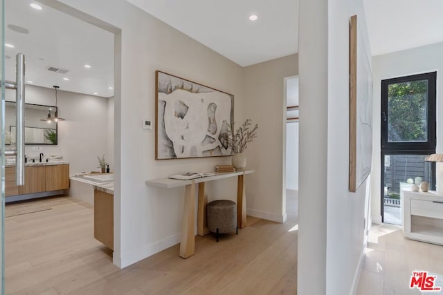 hallway with sink and light hardwood / wood-style floors