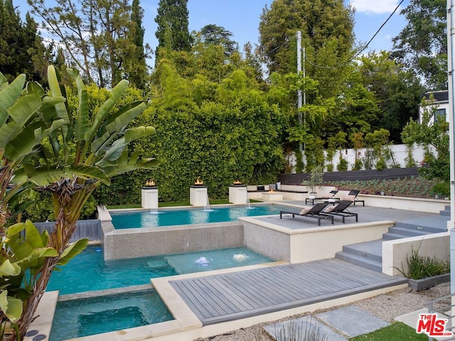 view of pool featuring pool water feature and an in ground hot tub