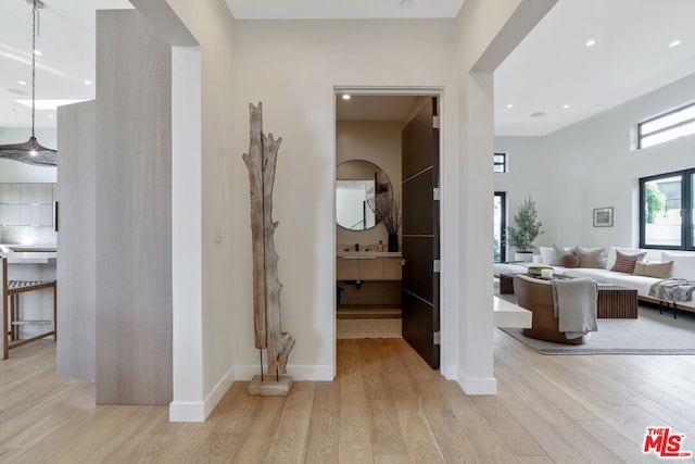 corridor featuring sink and light wood-type flooring