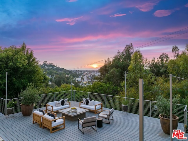 deck at dusk featuring an outdoor hangout area