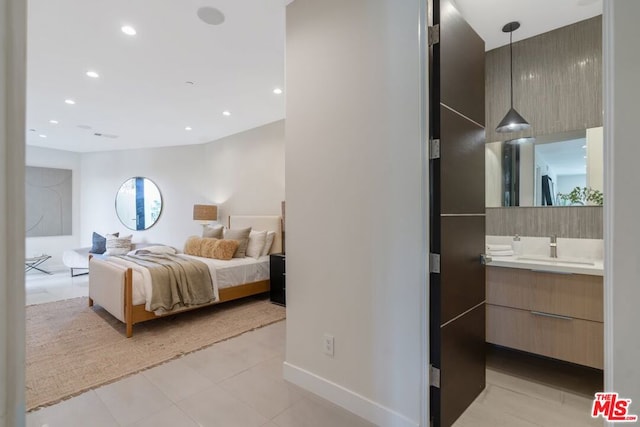 bedroom featuring ensuite bathroom and sink