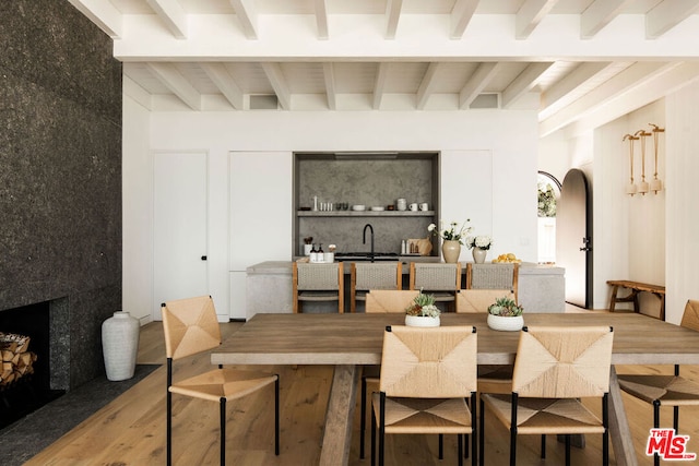 dining room featuring hardwood / wood-style floors and beam ceiling