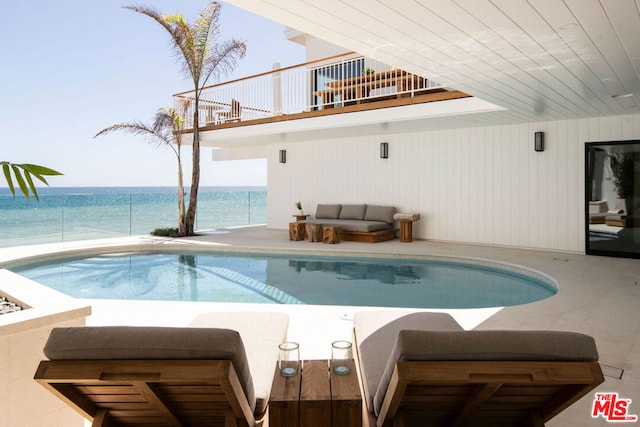 view of pool with a water view and an outdoor living space