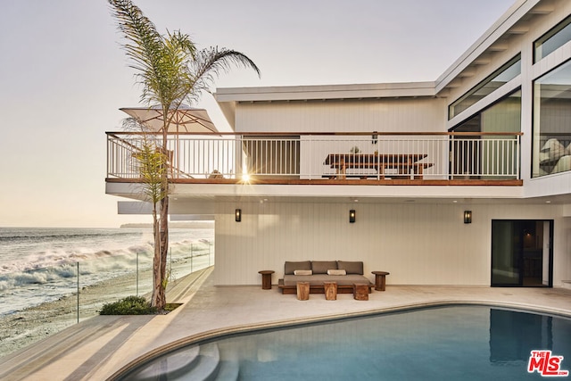 back of house with a water view and a balcony