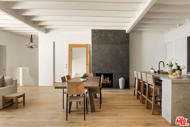 dining room with an inviting chandelier, light hardwood / wood-style flooring, and beamed ceiling