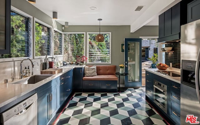 kitchen featuring stainless steel appliances, sink, hanging light fixtures, and a wealth of natural light