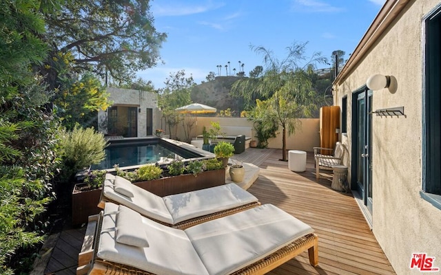 deck featuring a fenced in pool and a mountain view