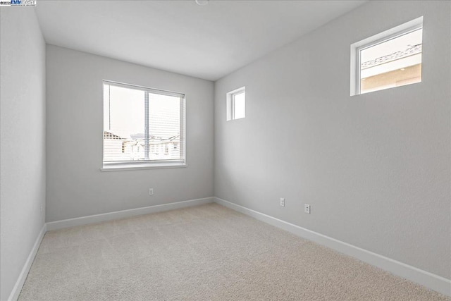 unfurnished room featuring light carpet