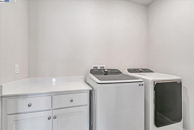 laundry room featuring cabinets and washer and clothes dryer