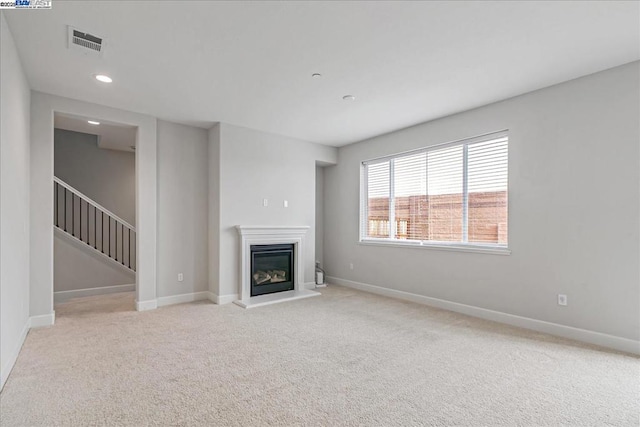 unfurnished living room featuring light carpet