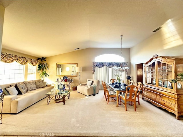 dining area featuring lofted ceiling, carpet flooring, and an inviting chandelier