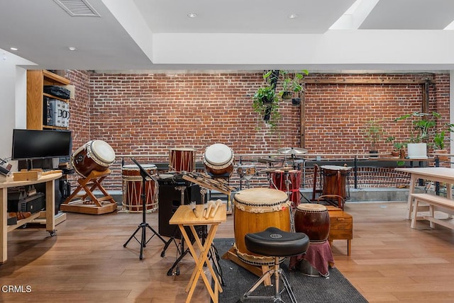 dining space with light hardwood / wood-style floors and brick wall