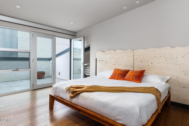 bedroom featuring access to exterior and hardwood / wood-style floors