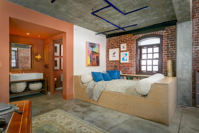 bedroom with brick wall and concrete flooring