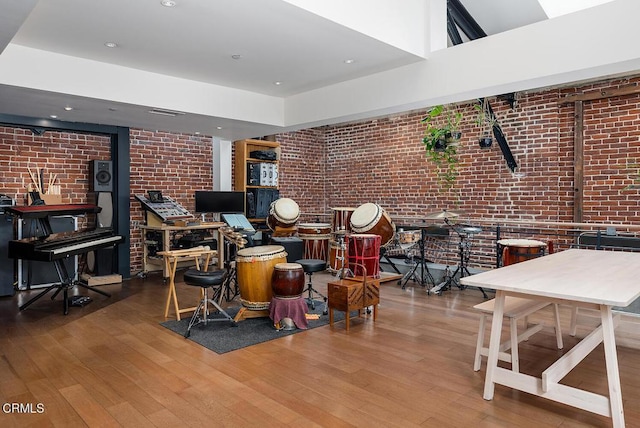 interior space with brick wall and hardwood / wood-style floors