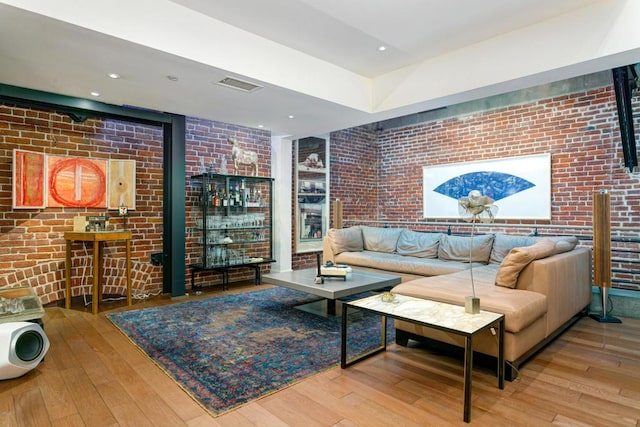 living room featuring brick wall and light wood-type flooring