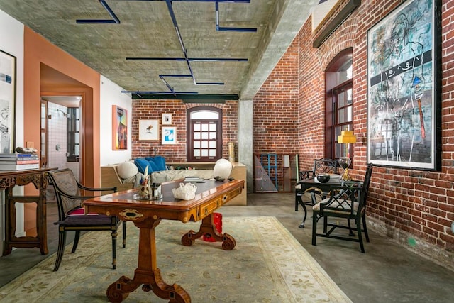 dining room with brick wall and concrete flooring