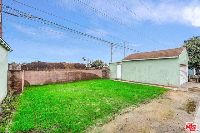 view of yard featuring a garage and an outbuilding