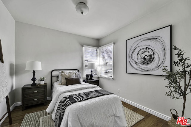 bedroom with dark hardwood / wood-style flooring