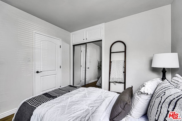 bedroom featuring dark hardwood / wood-style flooring and a closet