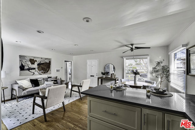 kitchen featuring dark hardwood / wood-style flooring, dark stone counters, and ceiling fan