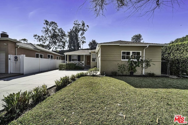 ranch-style house featuring a garage and a front lawn