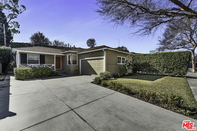 ranch-style house with a garage and a front lawn