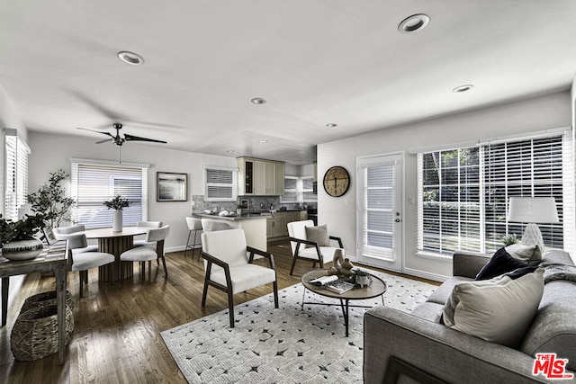 living room featuring ceiling fan and dark hardwood / wood-style floors