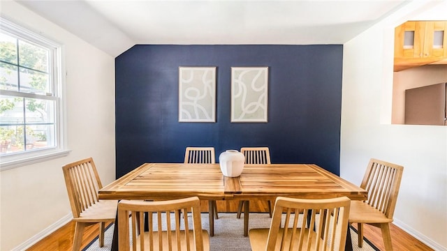 dining area featuring hardwood / wood-style floors and vaulted ceiling