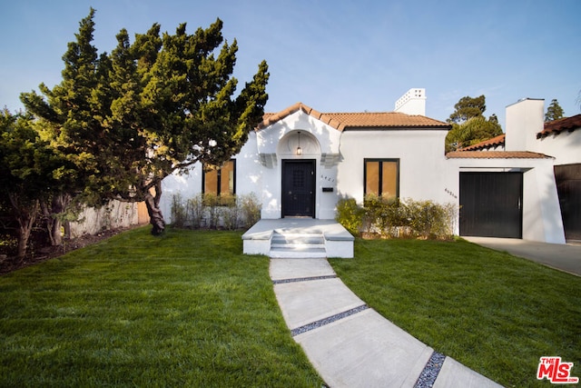 mediterranean / spanish house with a garage and a front yard