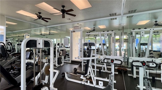 exercise room with ornamental molding, plenty of natural light, and a textured ceiling