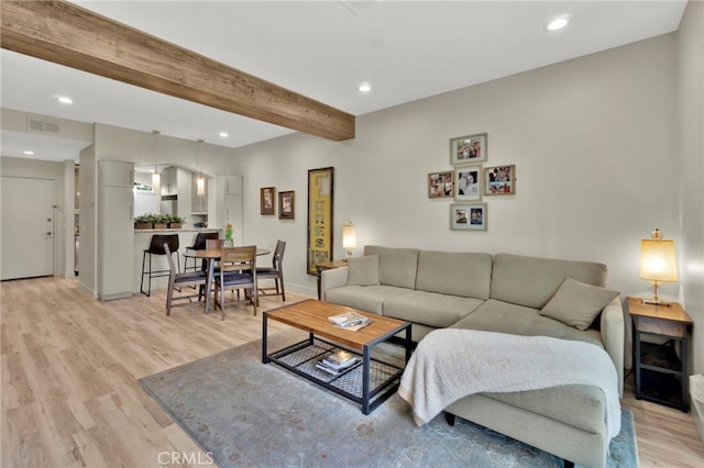 living room with beamed ceiling and light wood-type flooring