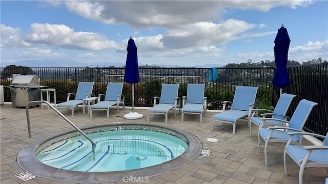 view of swimming pool with a patio, grilling area, and a community hot tub