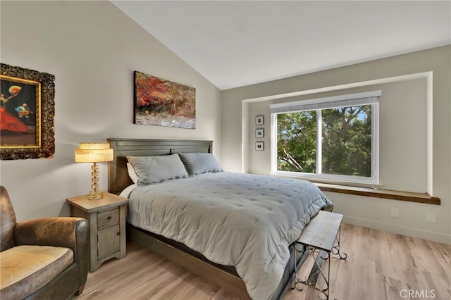 bedroom with lofted ceiling and light hardwood / wood-style floors