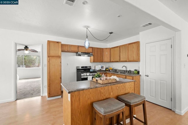 kitchen featuring a center island, stainless steel gas range, and a breakfast bar area