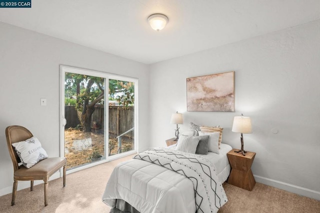 bedroom with access to outside and light colored carpet