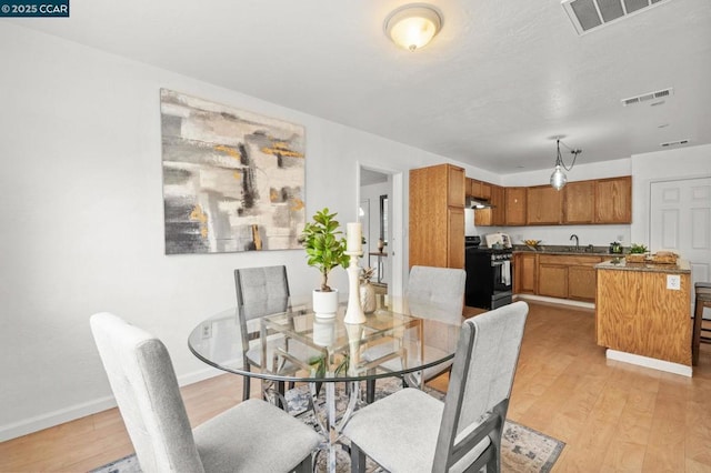 dining space featuring sink and light wood-type flooring