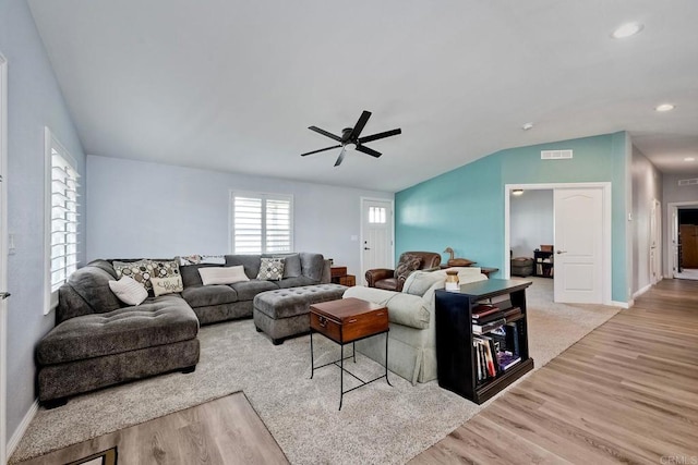 living room with ceiling fan, lofted ceiling, and light wood-type flooring