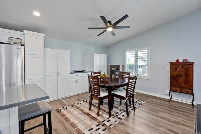 dining room featuring vaulted ceiling, ceiling fan, and light wood-type flooring