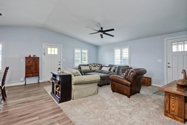 living room with ceiling fan, lofted ceiling, a healthy amount of sunlight, and light hardwood / wood-style floors