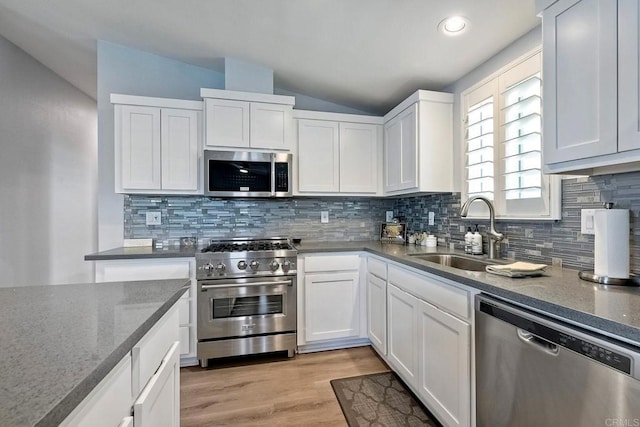 kitchen featuring stainless steel appliances, white cabinetry, sink, and light hardwood / wood-style flooring