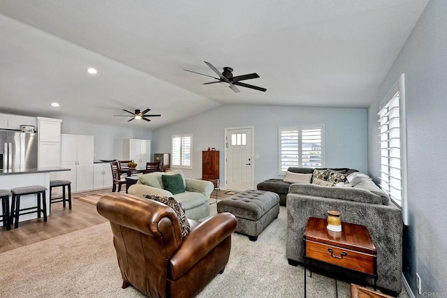 living room with lofted ceiling, ceiling fan, and light hardwood / wood-style flooring