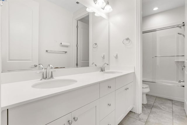 full bathroom featuring vanity, shower / bath combination with glass door, and toilet