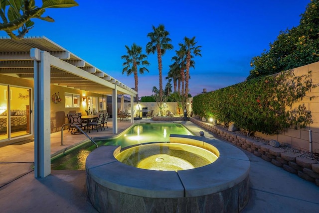 pool at dusk featuring an in ground hot tub and a patio