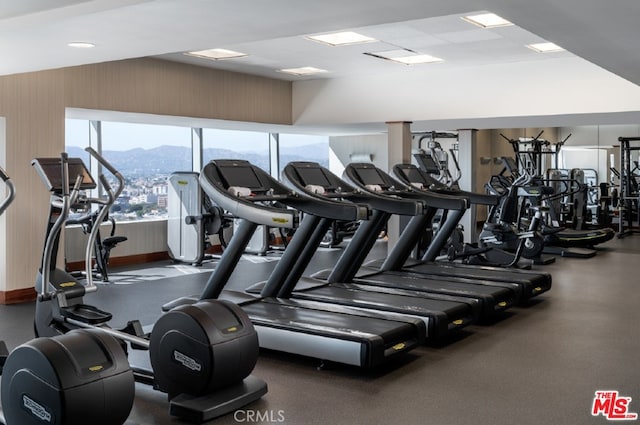 workout area featuring a paneled ceiling and a mountain view