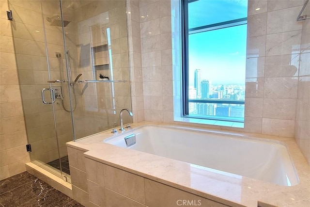 bathroom featuring plus walk in shower and tile walls