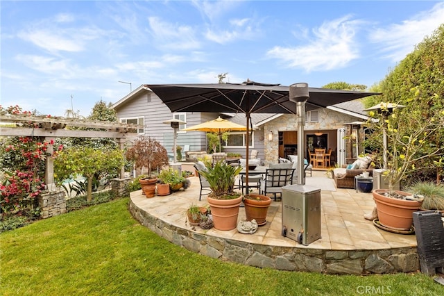 back of property with a yard, stone siding, a patio, and an outdoor hangout area