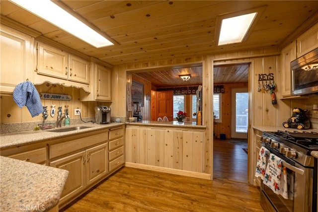 kitchen featuring appliances with stainless steel finishes, light wood-type flooring, light brown cabinets, and wood ceiling