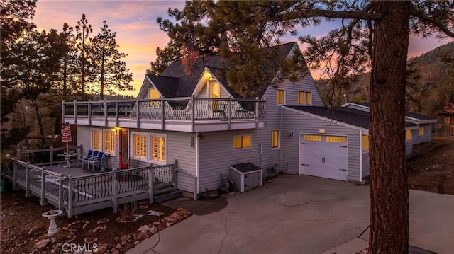 back house at dusk with a wooden deck